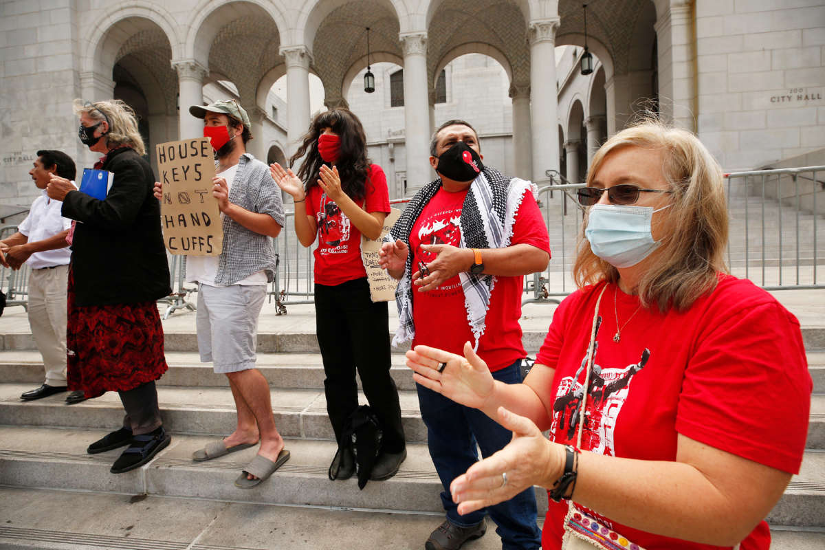 Elizabeth Blaney, right, with Union de Vecinos in the LA Tenants Union, chants with others as they listen to speakers talk about living unhoused from the steps of Los Angeles City Hall on May 19, 2021, in Los Angeles, California.