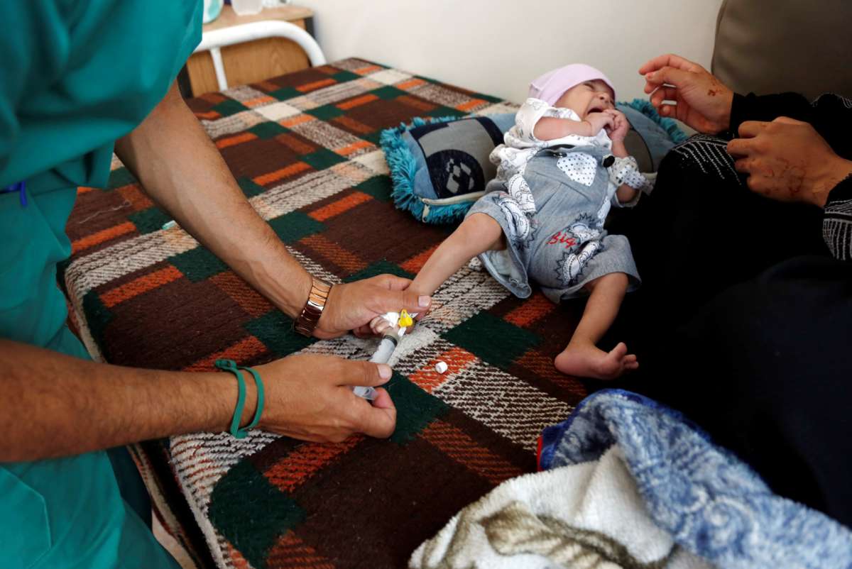 A severely malnourished infant recieves saline through a space between her toes