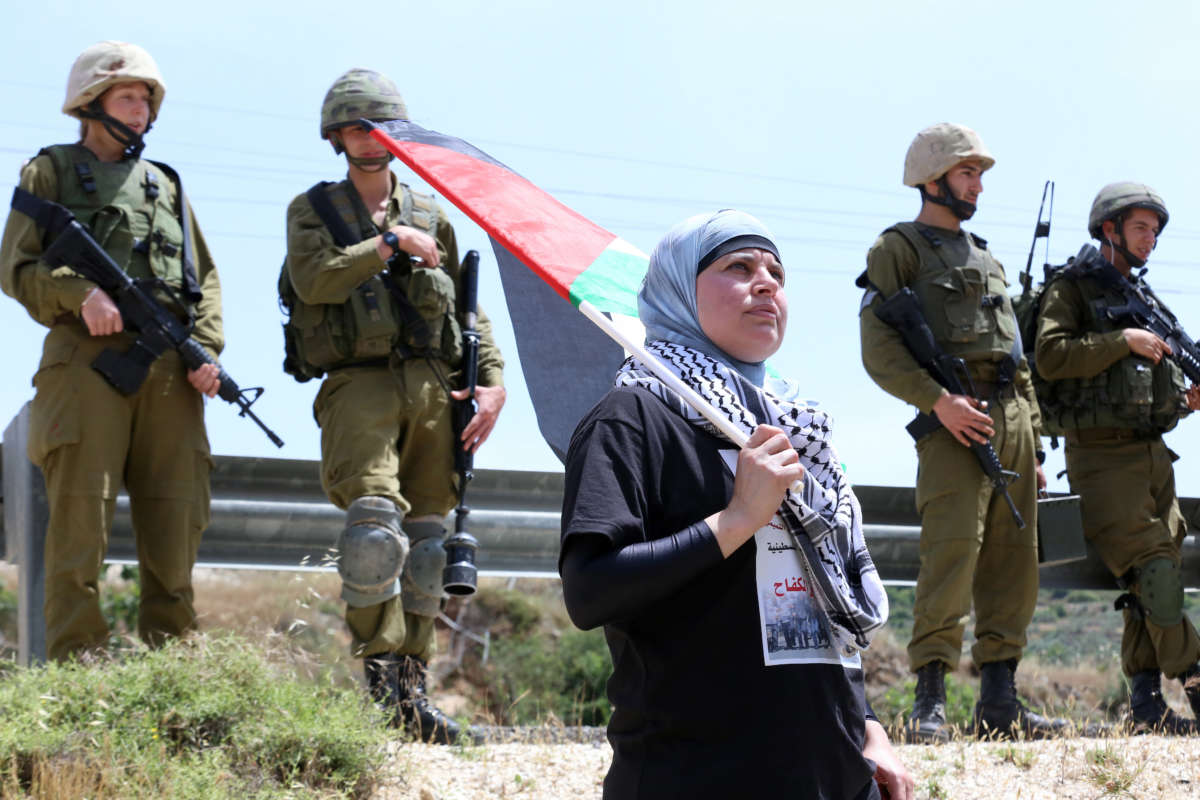 Manal Tamimi protests against settler-only roads in 2013 in Nabi Saleh, Palestine. The Israeli military denies Palestinians free use of these roads that are built on stolen land. 