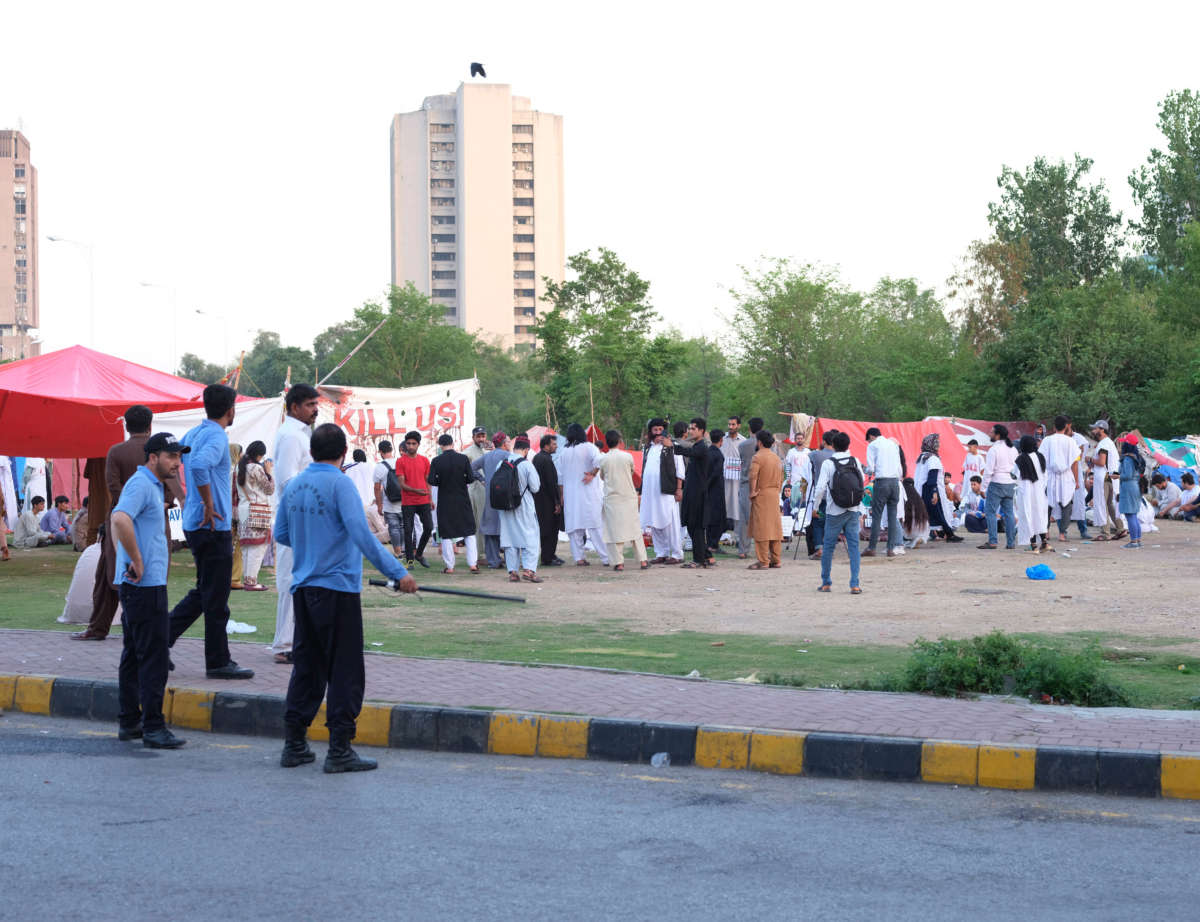 Protest banners and communal space at an Afghan refugee encampment in Islamabad, Pakistan.