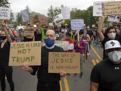 A priest stands with protesters as they hold a demonstration near the John Paul II Shrine during President Trump's visit in Washington, D.C., on June 2, 2020.