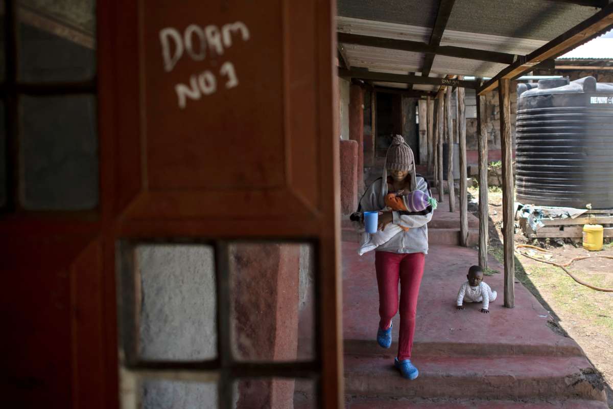 A teenage mother breastfeeds her infant as she heads to the dormitory during a tea-break from her classes at the Serene Haven Girl's Secondary School, an informal school that boards young mothers with their infants, some of whom are victims of sexual violence, in Kyeni, Kenya, on September 24, 2021.