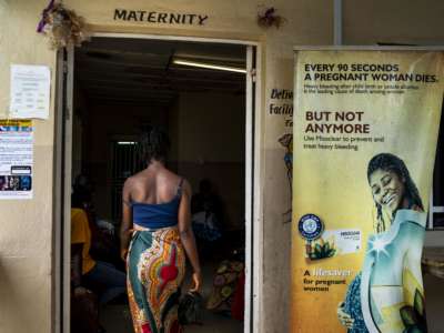 A woman enters a maternity clinic in Sierra Leone