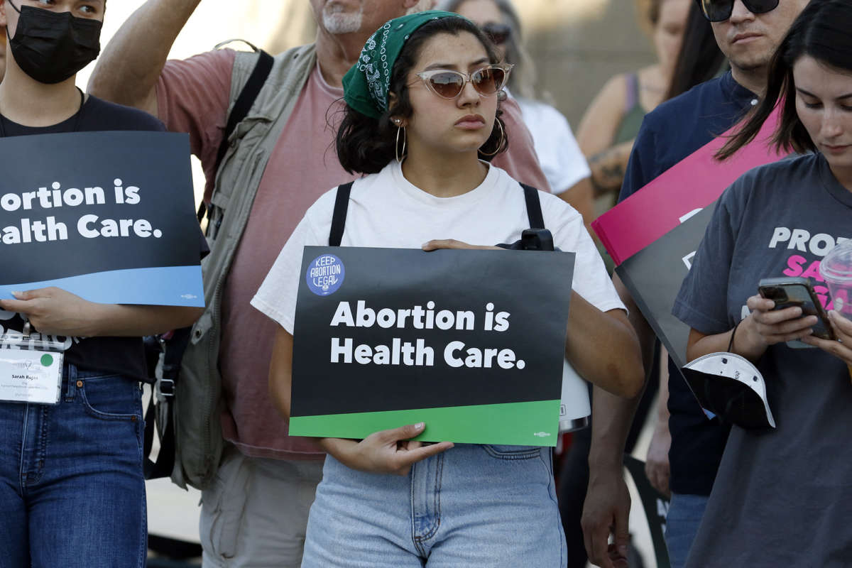 Young woman holding sign that says "Abortion is Healthcare"