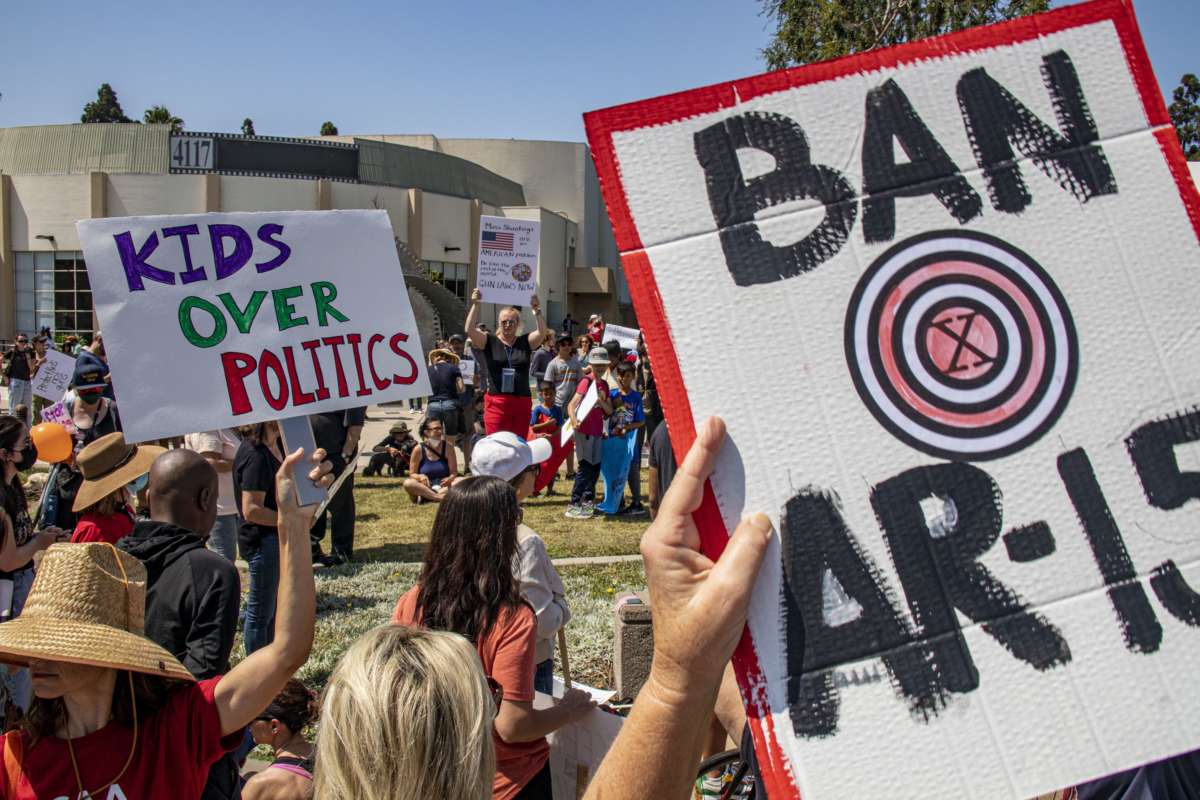 Prostestors hold signs that read "Ban AR-15s" and "Kids Over Politics"