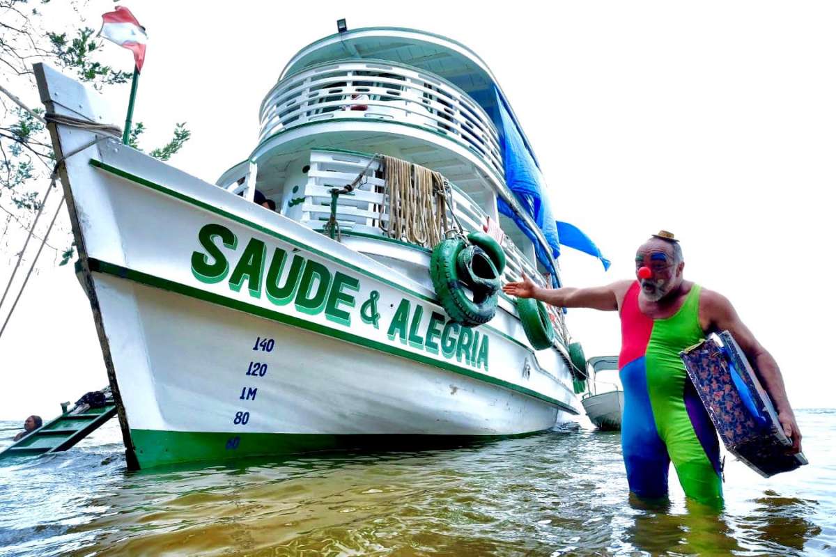 A clown named Curumim arriving at Aldeia Solimoes, in the Amazon, in one of Saúde e Alegria hospital boats.