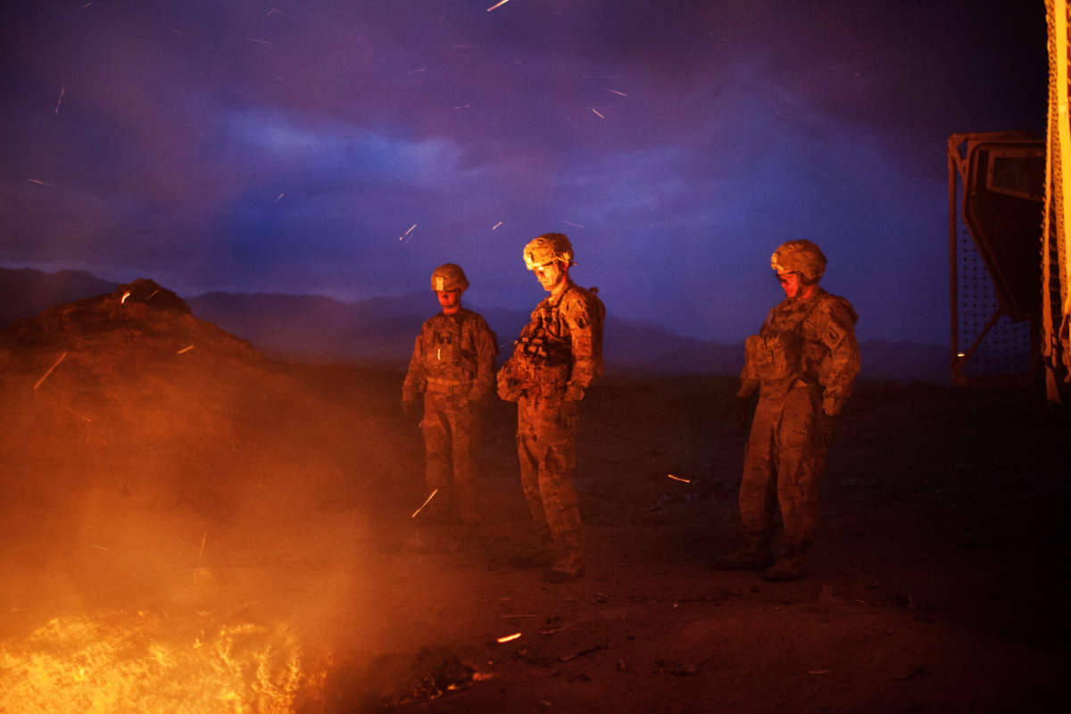 Soldiers burn trash from the Jaghatu Combat Outpost in a pit located just outside the walls of the base in Jaghatu, Afghanistan, on September 12, 2012.