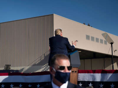 A secret service agent stands by as then-President Donald Trump speaks during a Make America Great Again rally at Phoenix Goodyear Airport on October 28, 2020, in Goodyear, Arizona.
