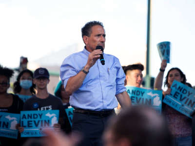 Andy Levin speaks into a microphone, his face stern