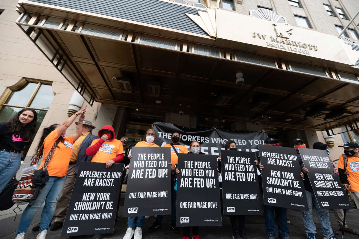 New York City restaurant workers rally outside Dine Brands shareholder meeting with signs reading 'the people who feed you are fed up' and 'Applebee's & Ihop are racist. New York shouldn't be. One Fair Wage Now!''