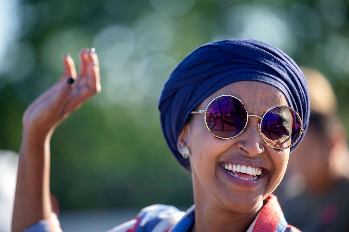 Rep. Ilhan Omar smiles as she waves to supporters