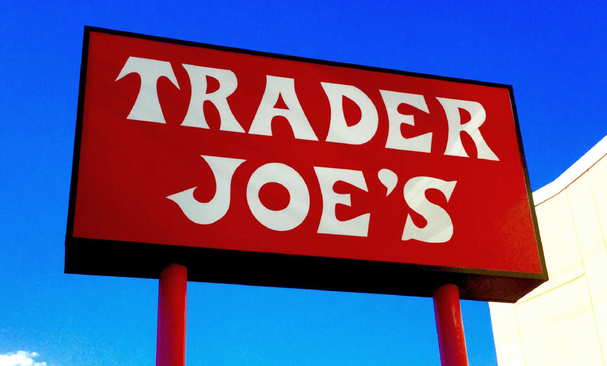 A red sign for Trader Joe's over a clear blue sky