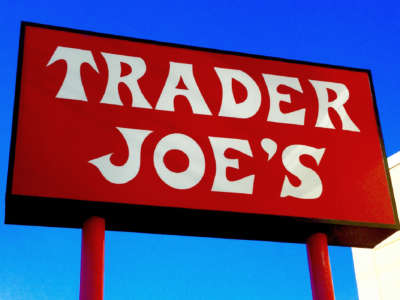 A red sign for Trader Joe's over a clear blue sky