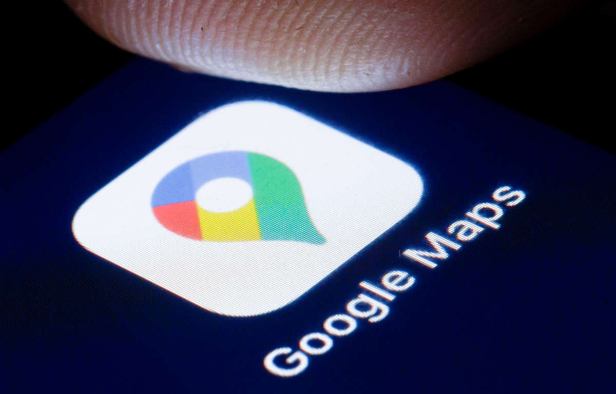 A finger hovers over the logo of the online map service Google Maps is shown on the display of a smartphone.