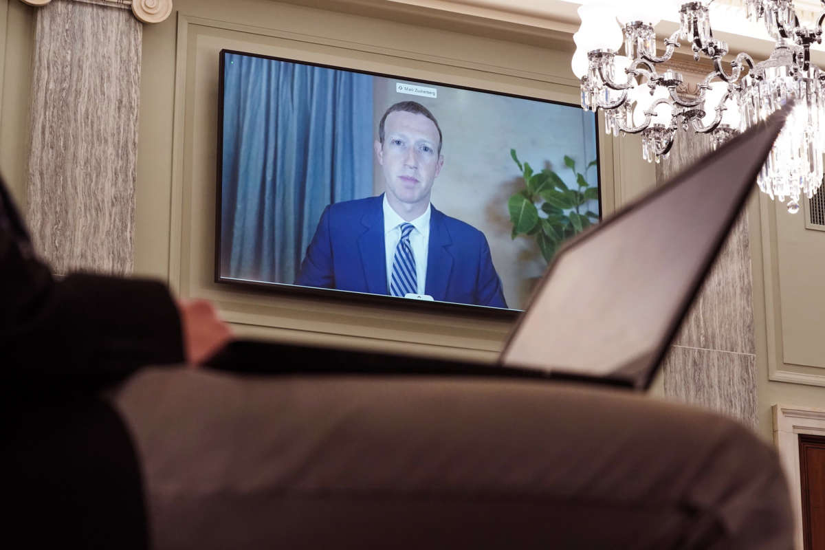 Mark Zuckerberg is seen on a television screen during a hearing