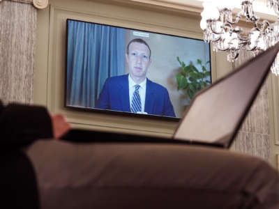 Mark Zuckerberg is seen on a television screen during a hearing