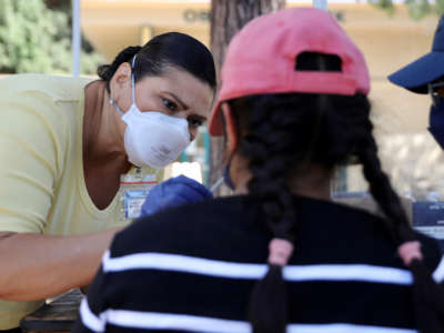 A medical worker collects a swab sample from a resident for a COVID-19 test in Los Angeles, California, on August 5, 2022.