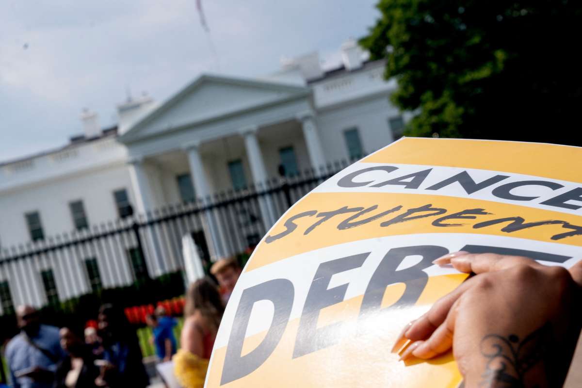 An activist holds a cancel student debt sign as they gather to rally in front of the White House in Washington, D.C., on August 25, 2022.