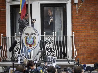 Julian Assange prepares to speak from the balcony of the Ecuadorian embassy