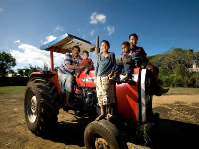 A man and his family sit together on a tractor