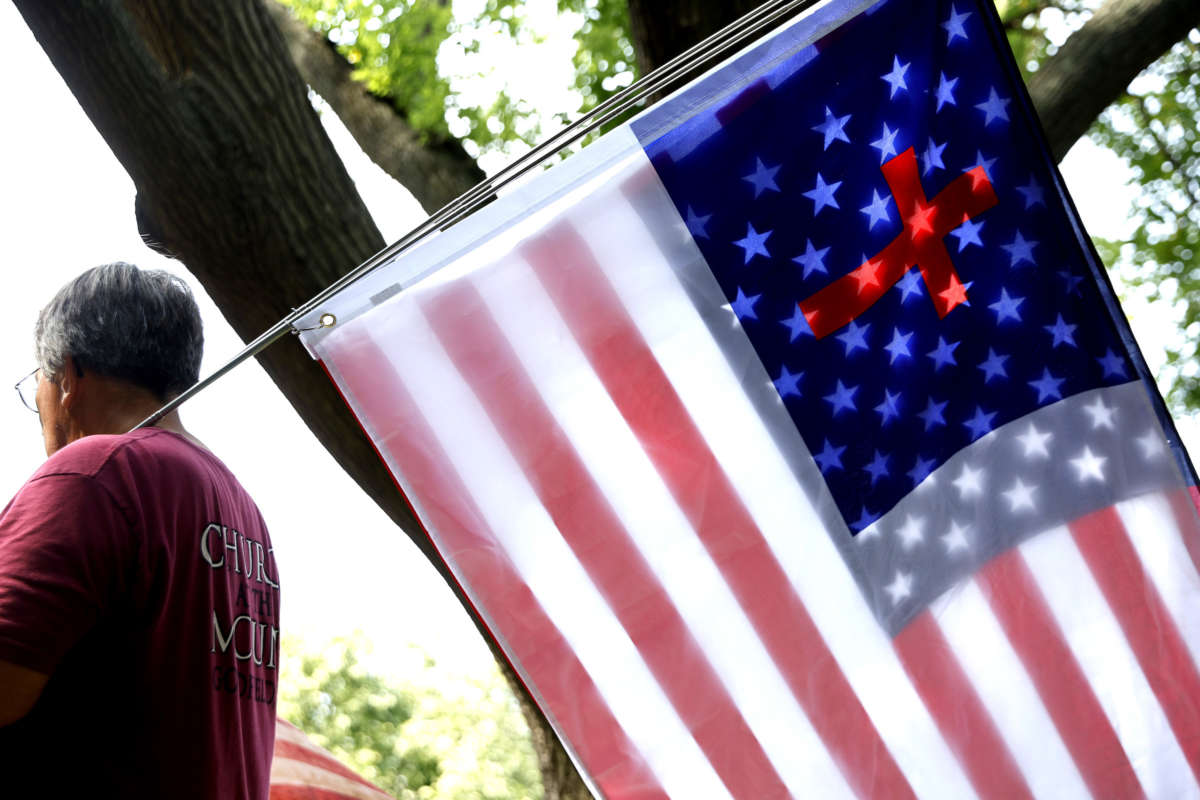 A United States and Christian flag are sandwiched together as supporters of the 1776 Restoration Movement rally outside the United States District Court House during the first day of jury selection in the trial of former White House senior advisor Stephen Bannon on July 18, 2022 in Washington, D.C.