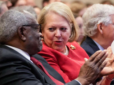 Associate Supreme Court Justice Clarence Thomas sits with his wife and conservative activist Virginia 'Ginni' Thomas while he waits to speak at the Heritage Foundation on October 21, 2021, in Washington, D.C.