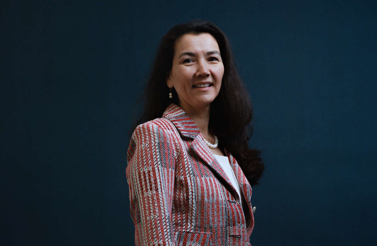 Alaska congressional candidate Mary Peltola is pictured, smiling, facing camera and standing against dark blue background