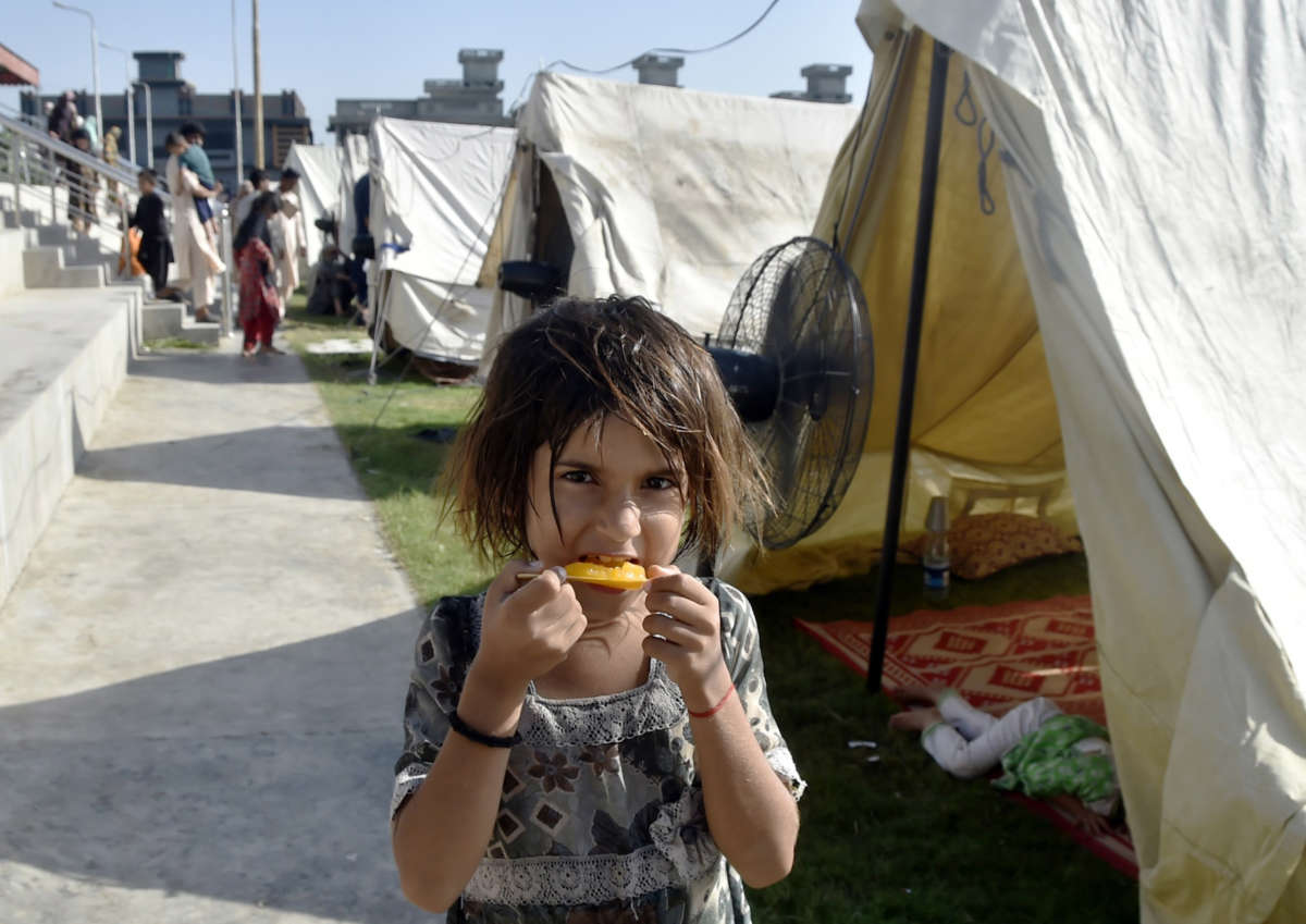 A flood-affected girl eats at a relief shelter in northwest Pakistan's Charsadda
