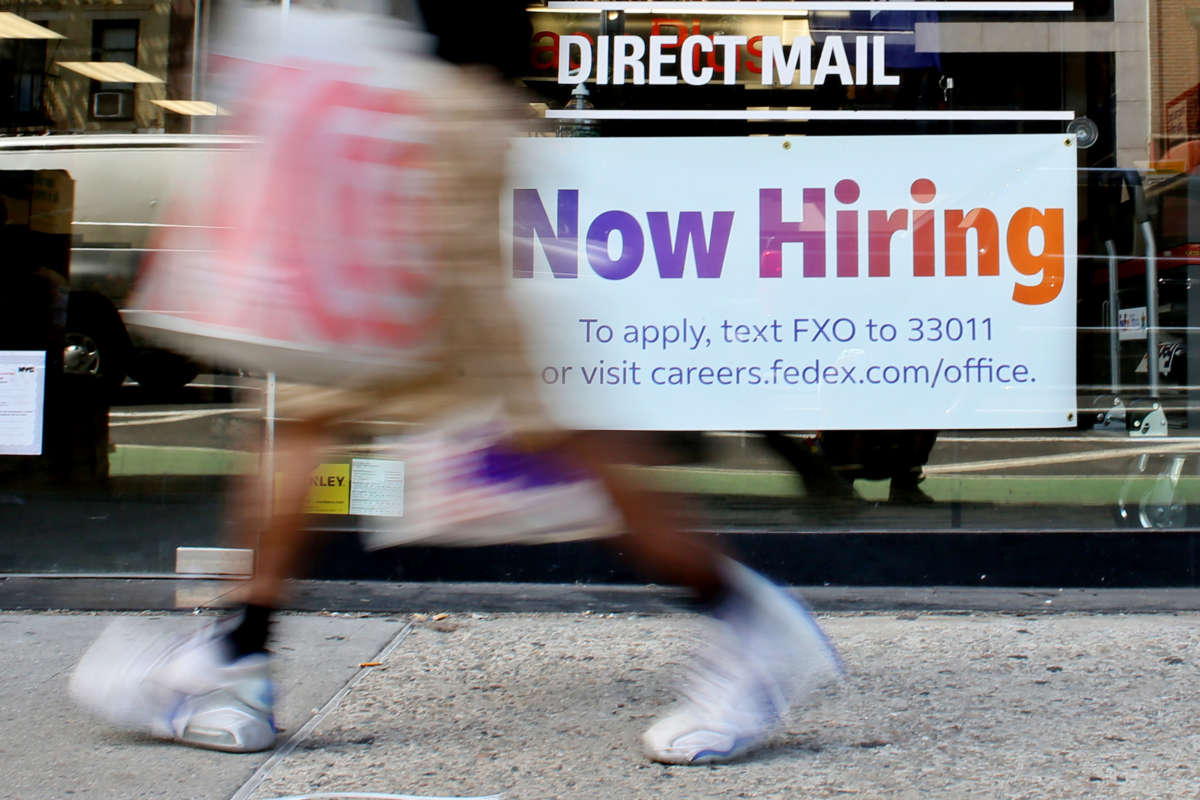 A 'Now Hiring' sign is displayed on a shopfront on August 5, 2022, in New York City.