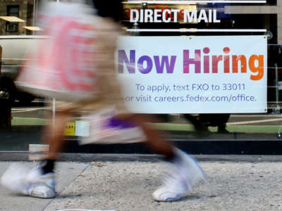 A 'Now Hiring' sign is displayed on a shopfront on August 5, 2022, in New York City.