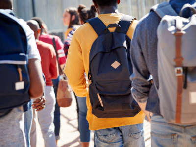 Students with backpacks walk away