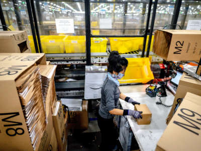 A worker packs items at Amazon fulfillment center in Eastvale, California, on August 31, 2021.