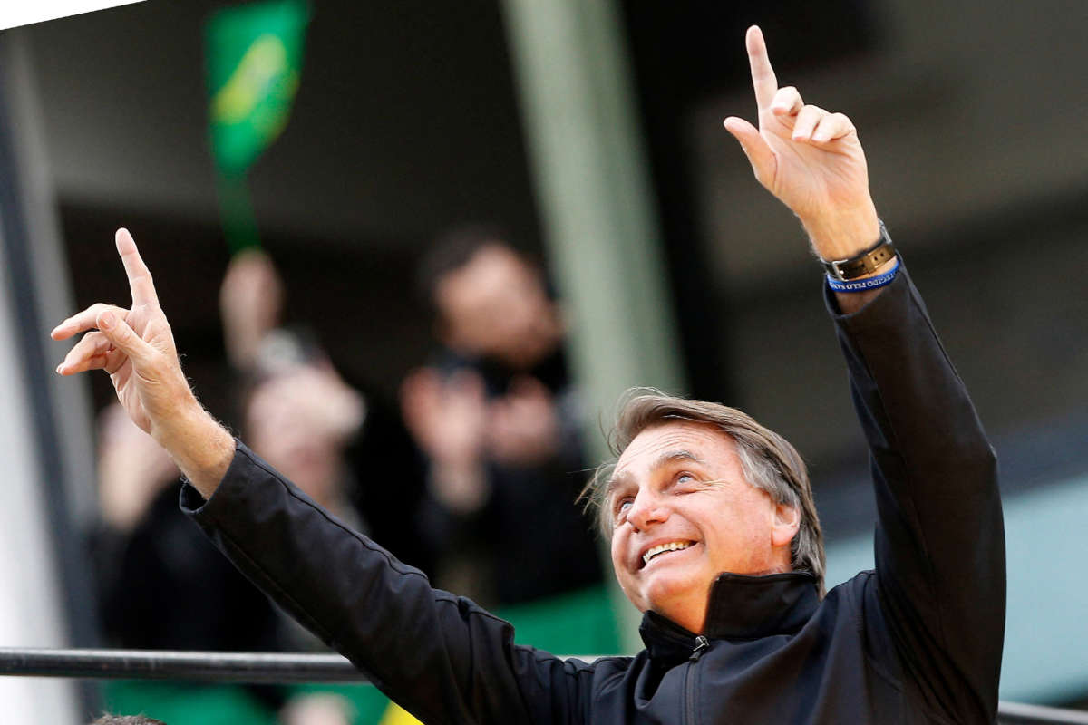 Brazil's president and presidential candidate Jair Bolsonaro points upward with both hands during a rally