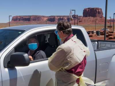 A doctor consults with a Navajo Indian woman with symptoms at a COVID-19 testing center at the Navajo Nation town of Monument Valley in Arizona on May 21, 2020.