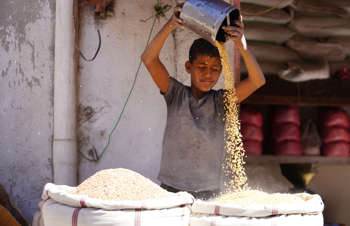 A seller and sacks of legumes are seen at a market area in Taiz, Yemen, on March 10, 2022.