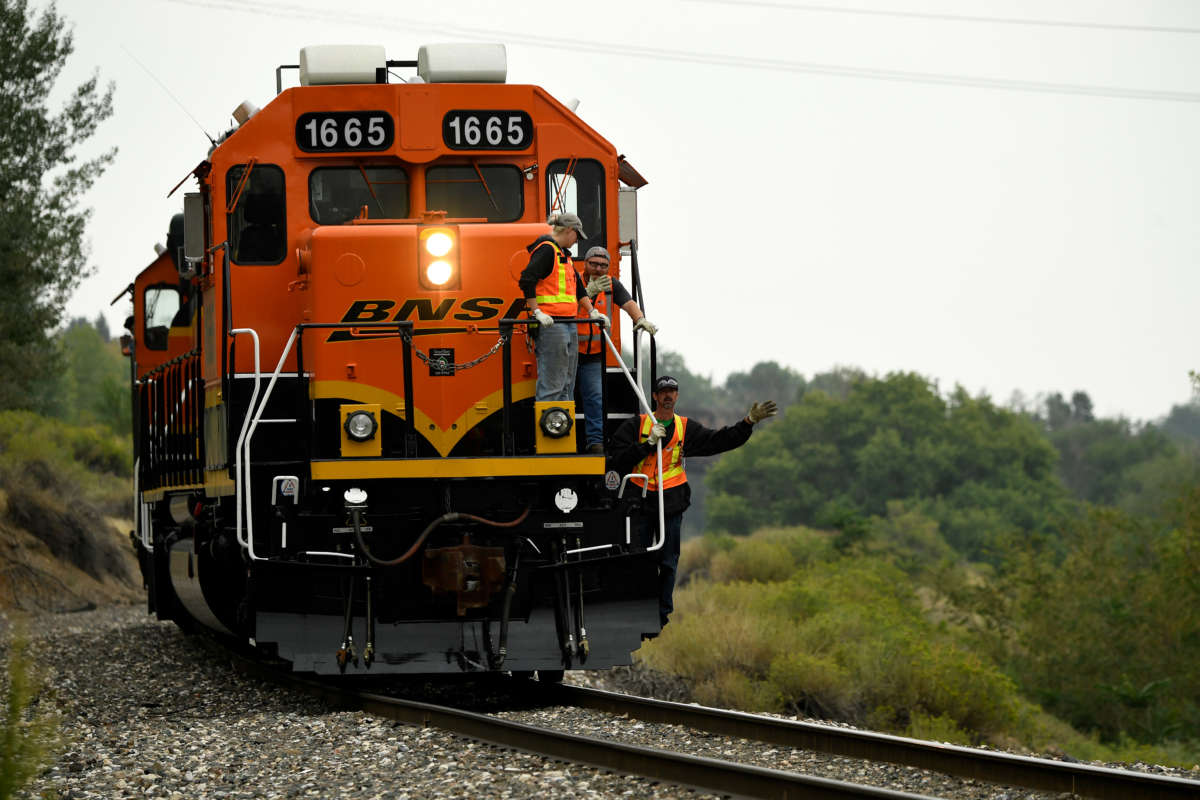 BNSF engines and workers ride a tunnel motor locomotive on August 22, 2018, in Golden, Colorado.
