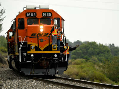 BNSF engines and workers ride a tunnel motor locomotive on August 22, 2018, in Golden, Colorado.