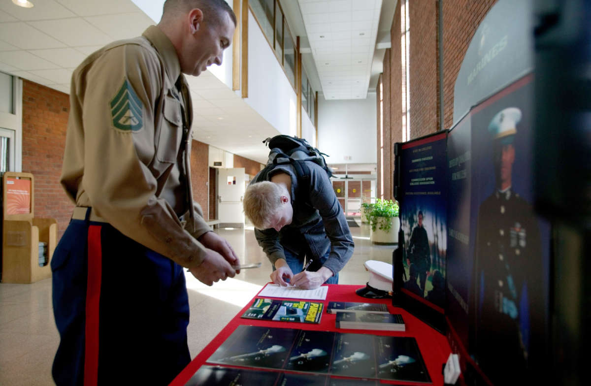 An undergraduate student writes down contact information for a U.S. Marine recruiter during a recruiting presentation on campus at Rutgers University on December 1, 2005, in New Brunswick, New Jersey.