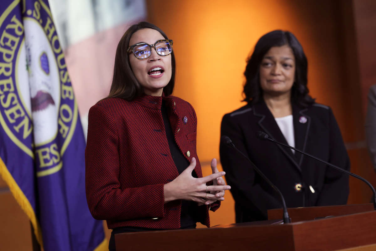 AOC speaks at a podium in a way that is visually reminiscent of a rebuke