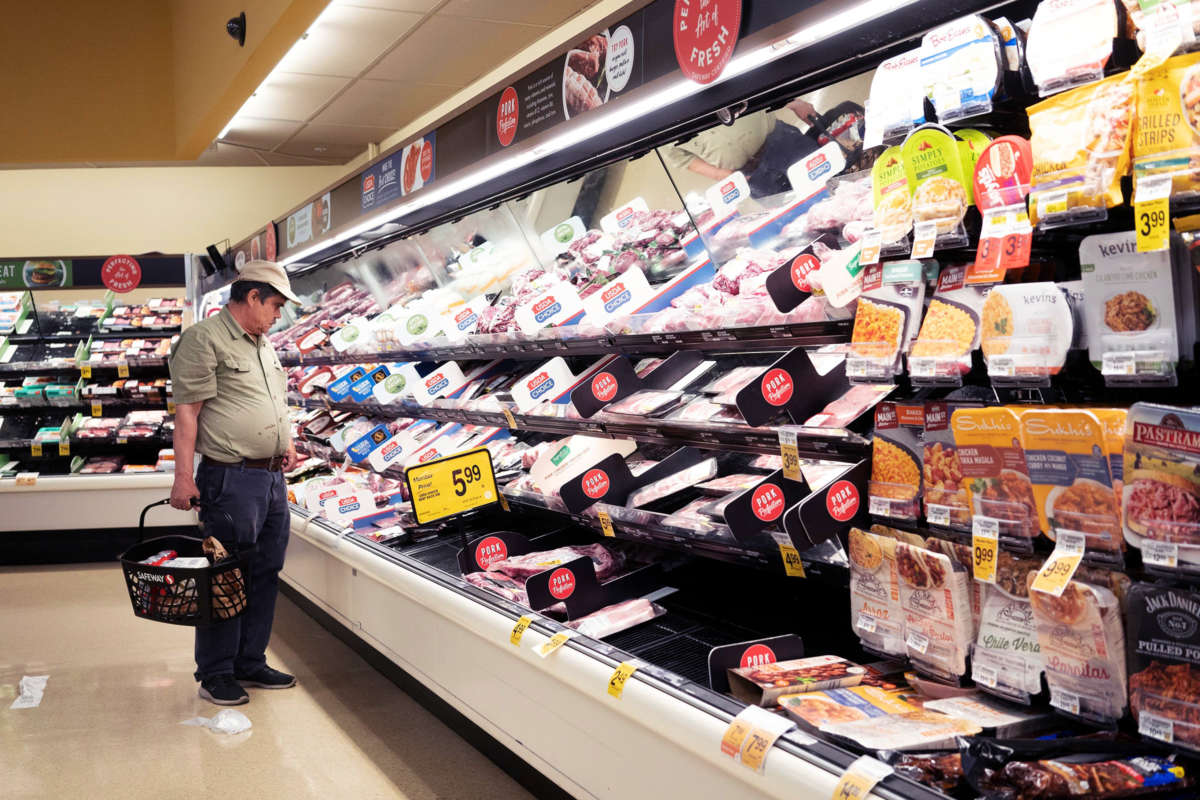 A man looks at meat in a grocery store