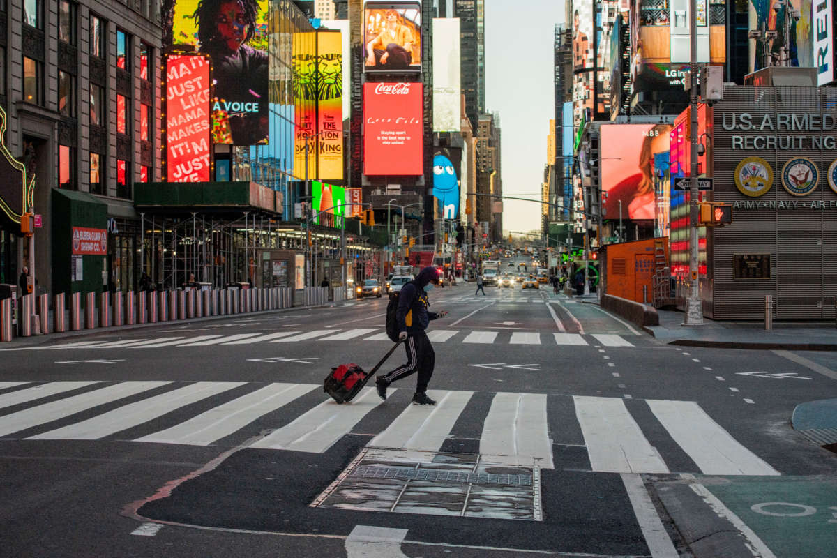 Pedestrians walk through en empty Times Square on March 27, 2020, in New York City.