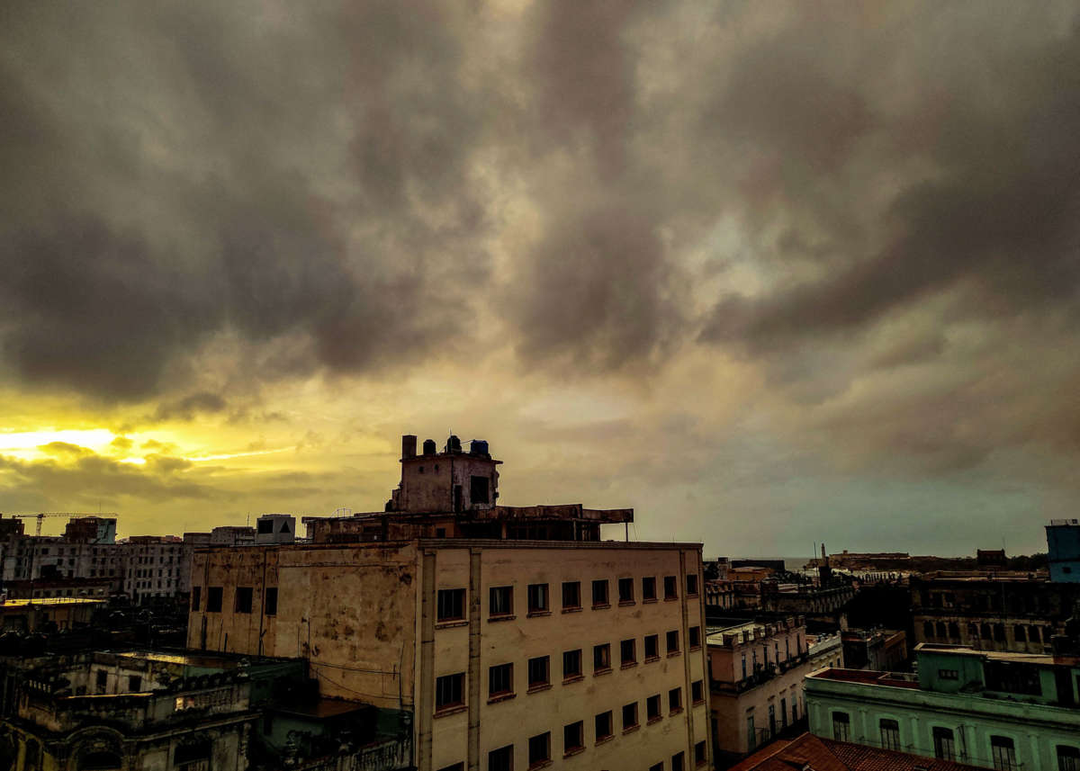 Buildings with no power are seen standing against a dark, cloudy sky