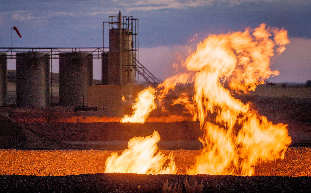 Flames billow from a flaring pit near a well in the Bakken Oil Field, pictured in 2011.