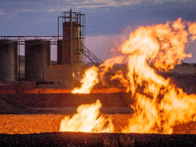 Flames billow from a flaring pit near a well in the Bakken Oil Field, pictured in 2011.