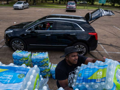 Residents distribute cases of water at Grove Park Community Center in Jackson, Mississippi, on September 3, 2022.