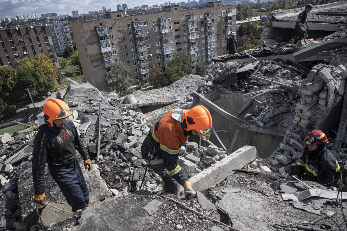Ukrainian firefighters remove debris from a building damaged by Russian airstrikes in Kharkiv, Ukraine, on September 22, 2022.