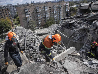 Ukrainian firefighters remove debris from a building damaged by Russian airstrikes in Kharkiv, Ukraine, on September 22, 2022.