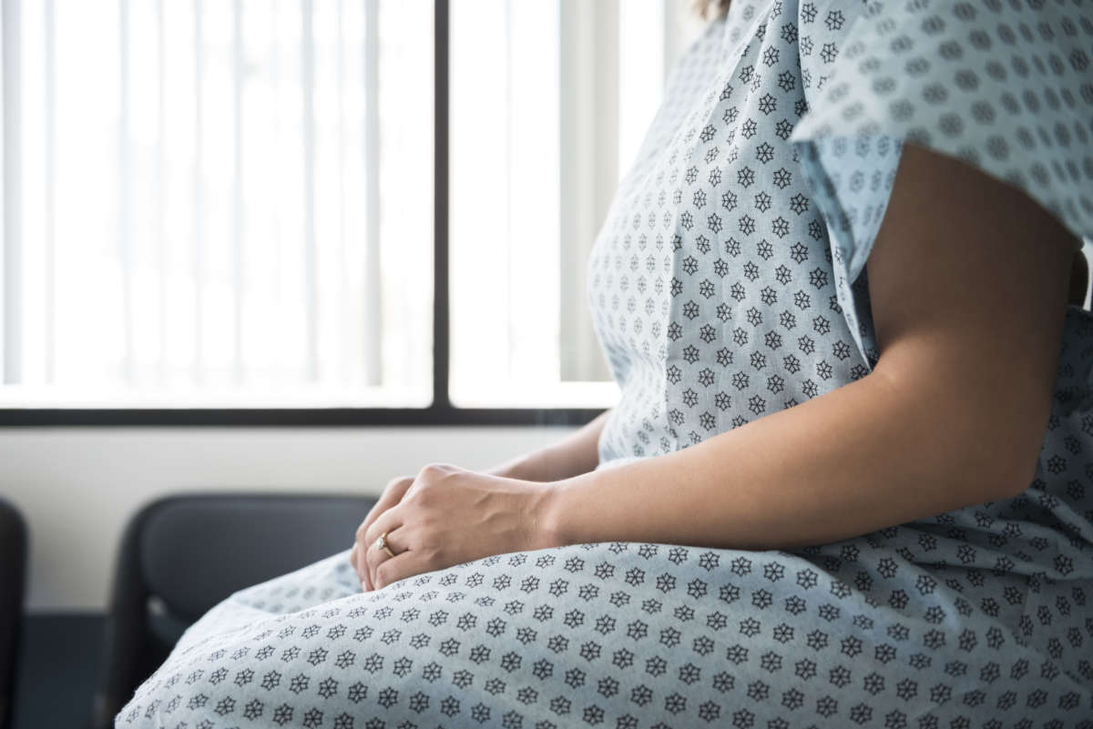 Woman in a hospital gown awaits diagnosis