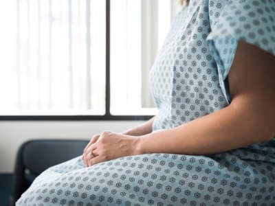 Woman in a hospital gown awaits diagnosis