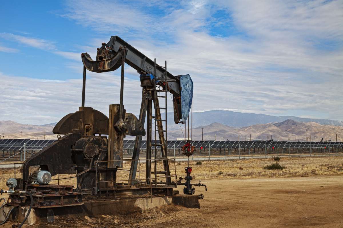 Lone pumpjack located in the middle of large solar array outside of Bakersfield